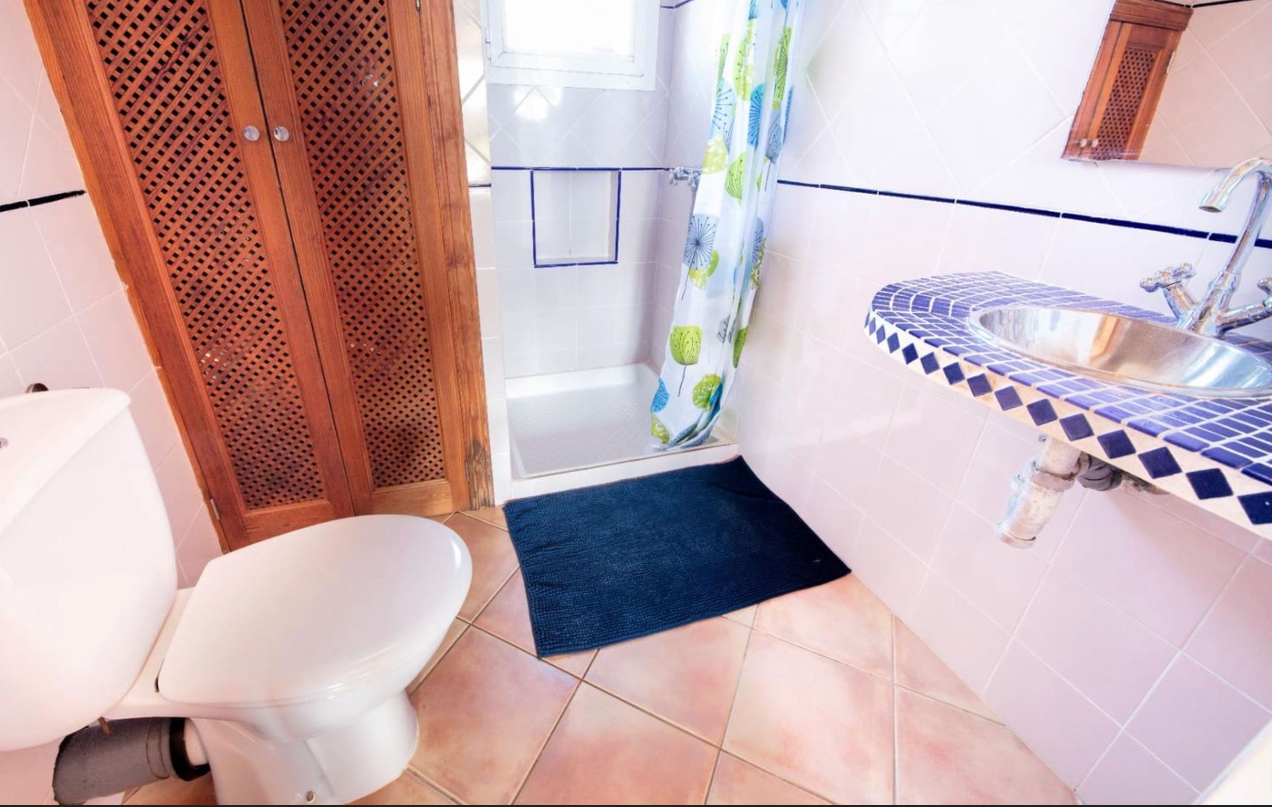 Bathroom with blue mosaic tile vanity and lattice cabinet doors