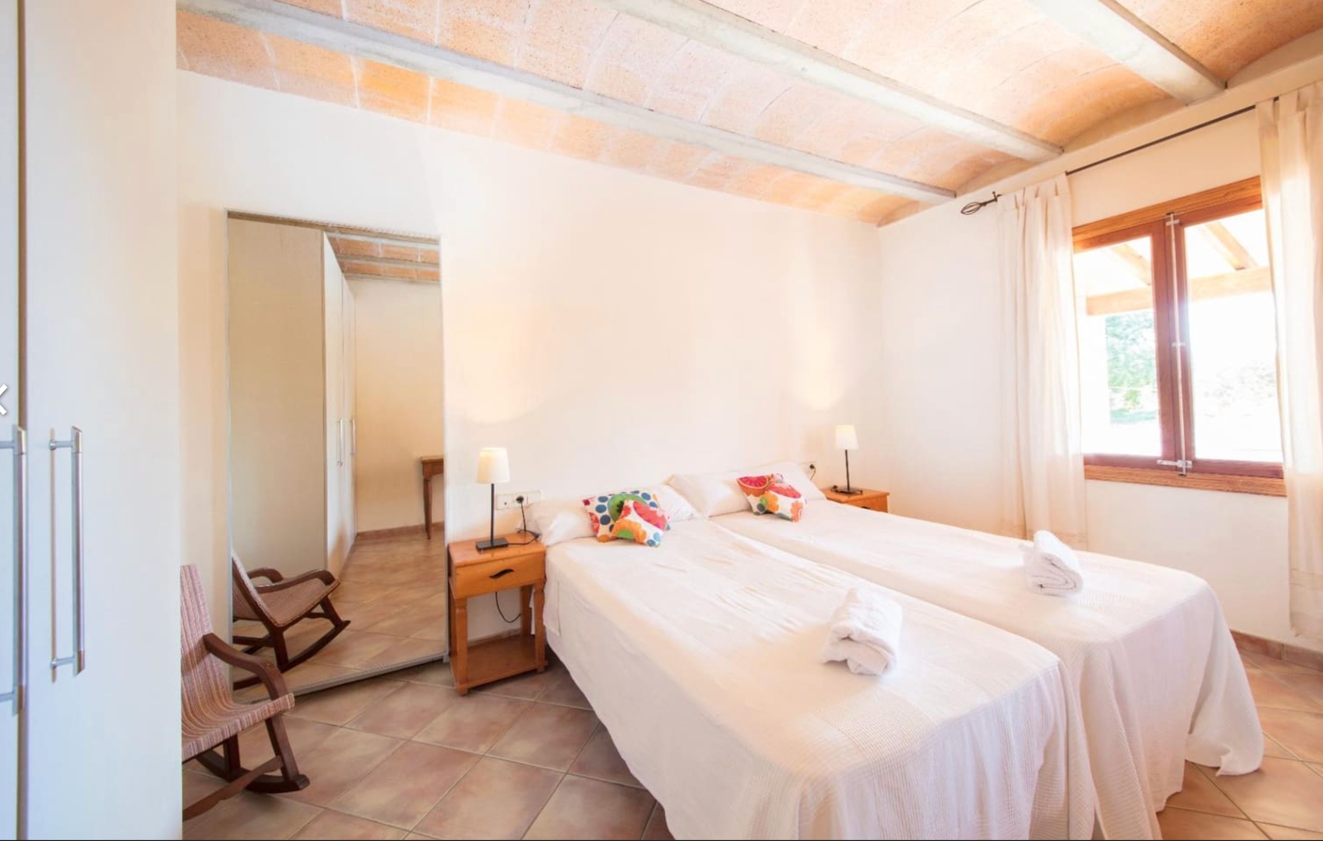 Spacious twin bedroom with terracotta floors and exposed beams