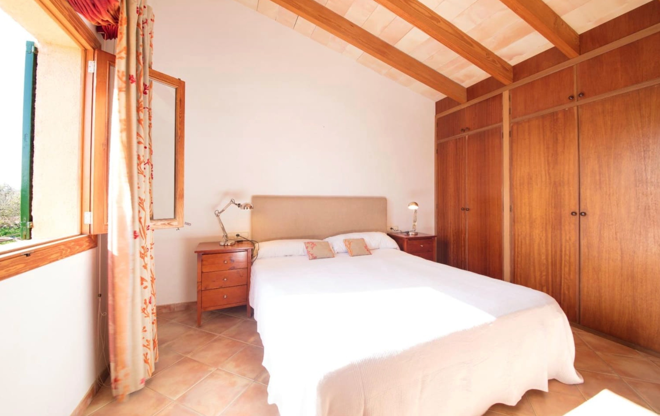 Master bedroom with beige headboard and wooden wardrobes