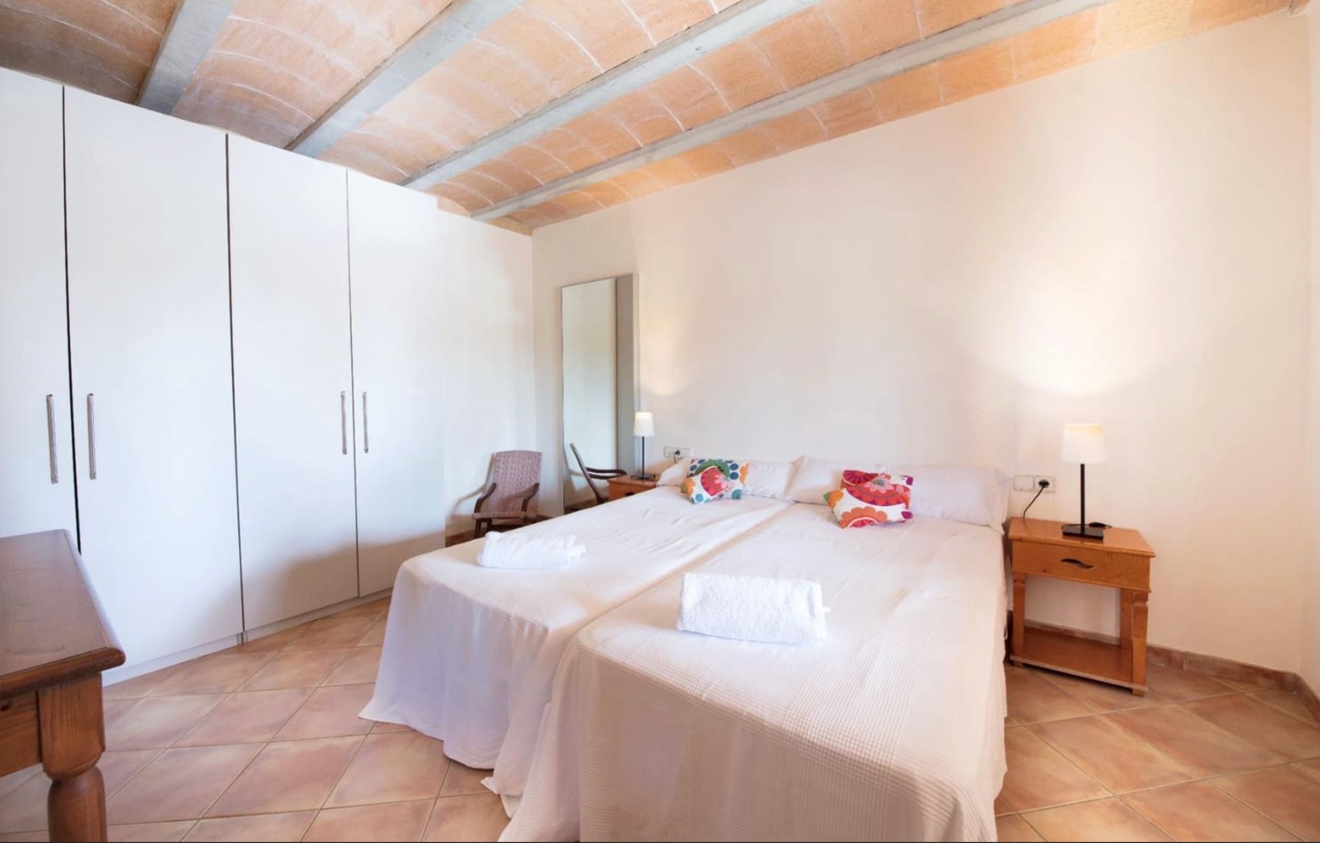 Master bedroom with white wardrobes and terracotta ceiling