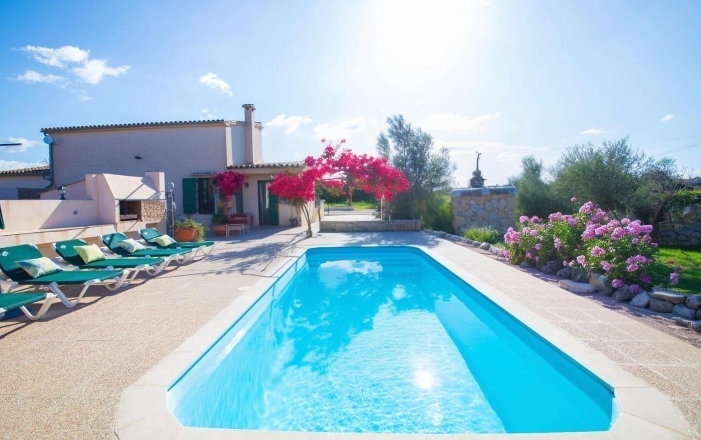 Pool area with villa and colorful bougainvillea flowers