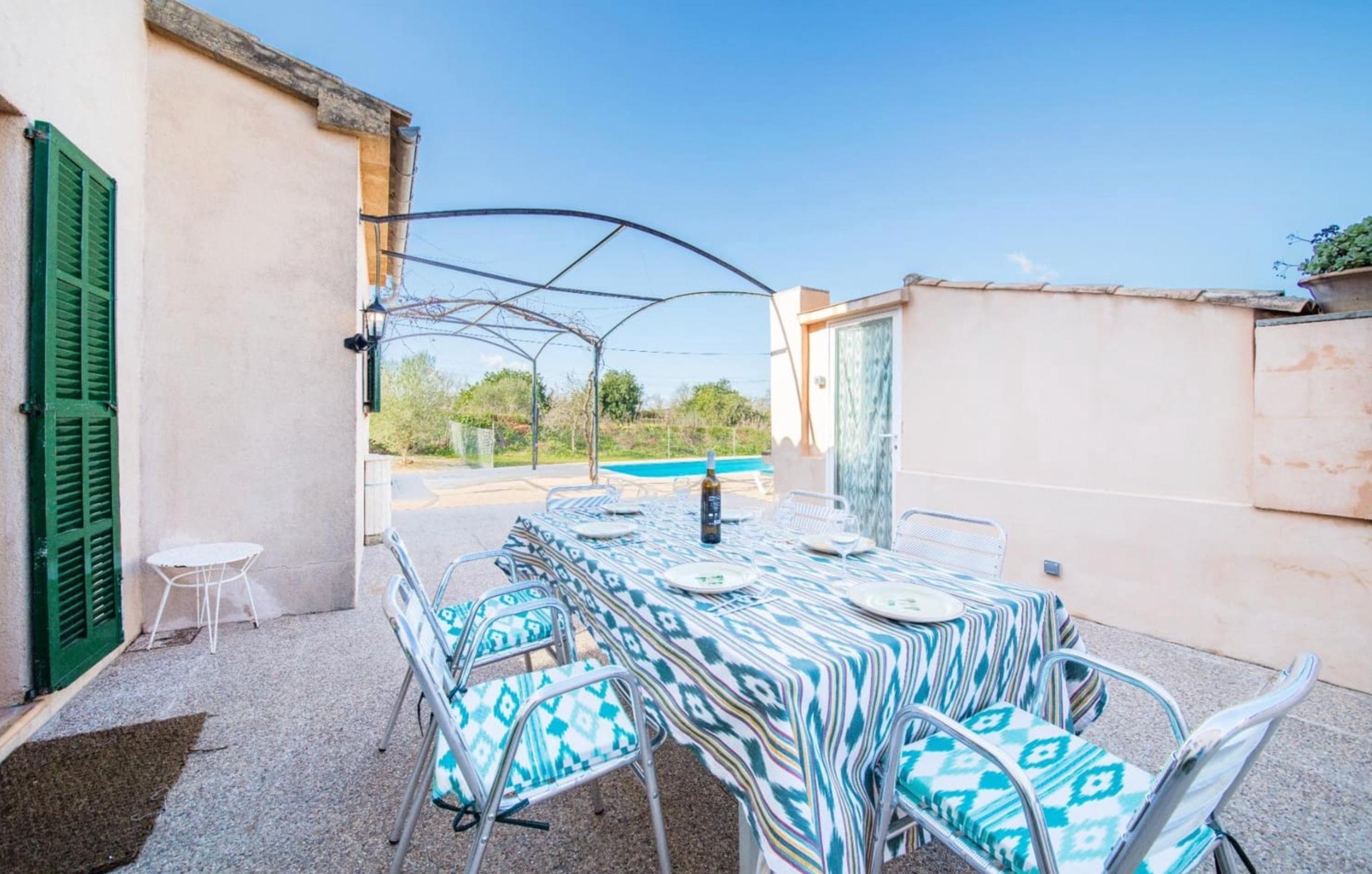 Outdoor terrace with dining table and turquoise patterned chairs