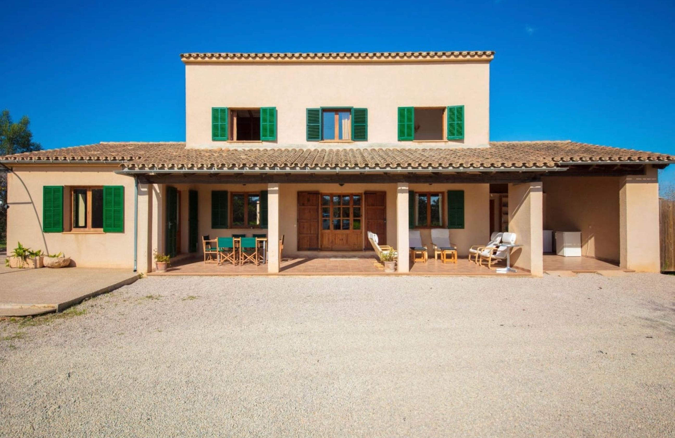 Front exterior of Eddra Villa with green shutters and covered terraces